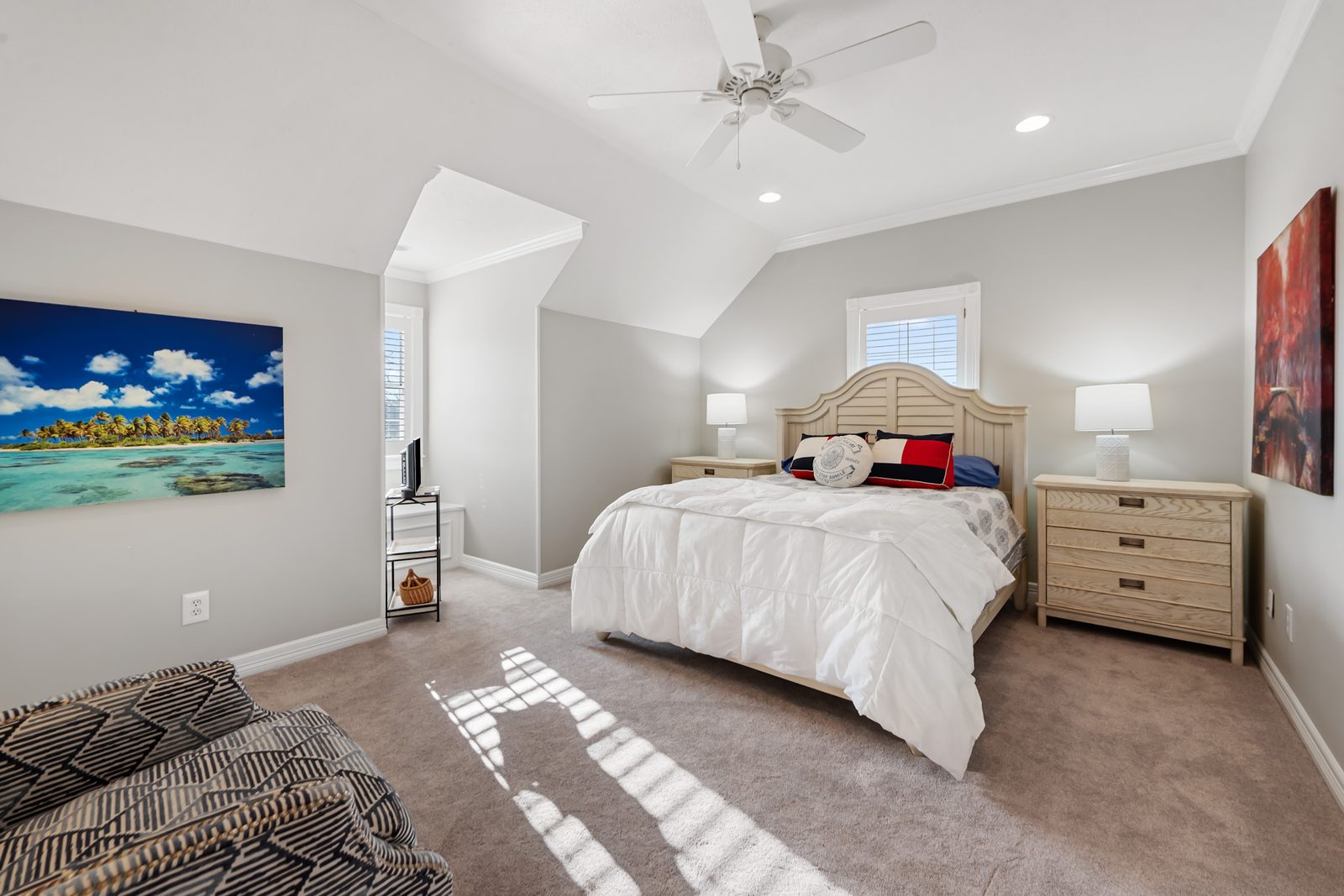 Upstairs bedroom with a queen bed, carpet, and a tropical photograph